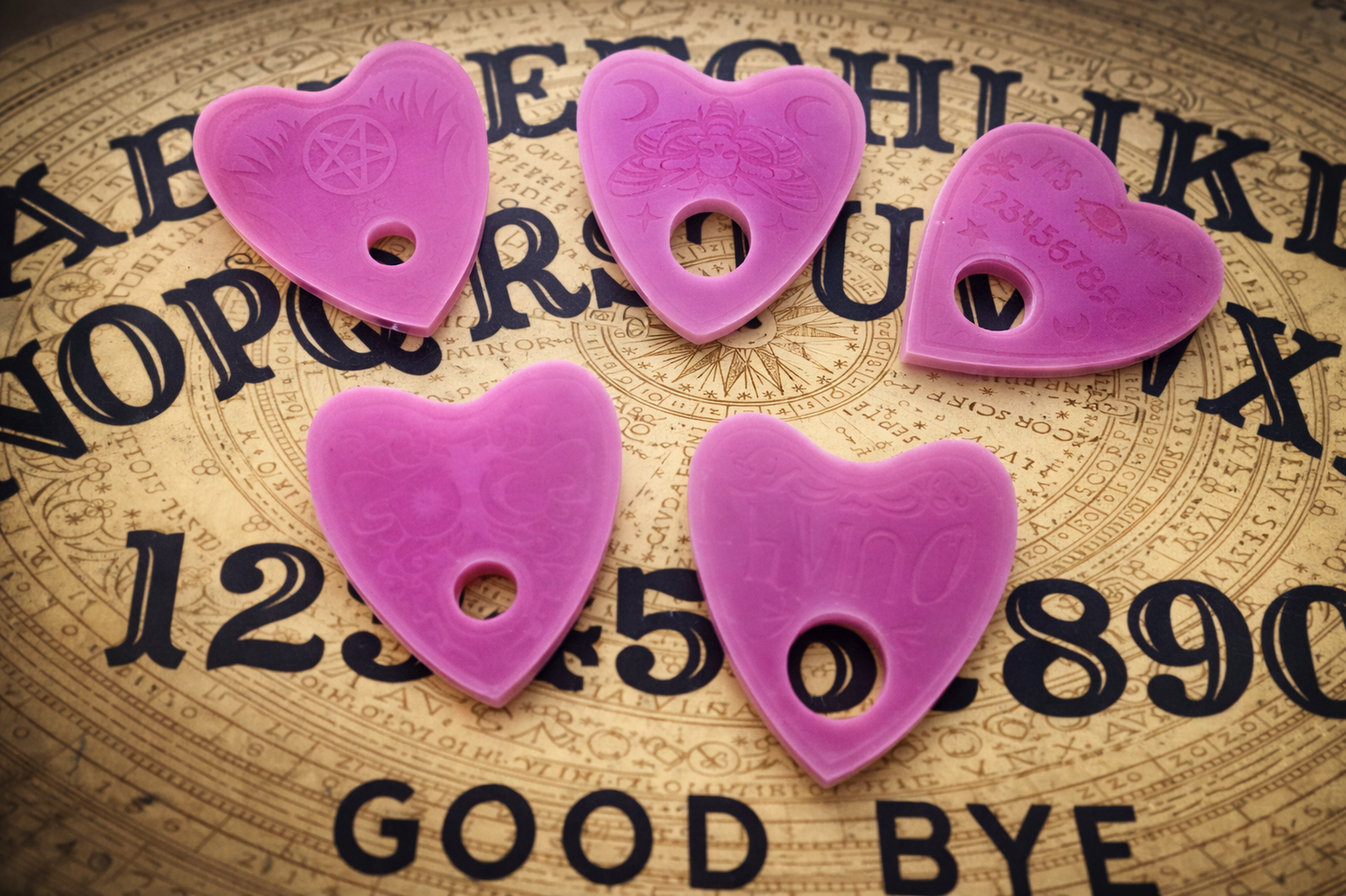 Five purple planchette-shaped objects on a vintage-style background with text.